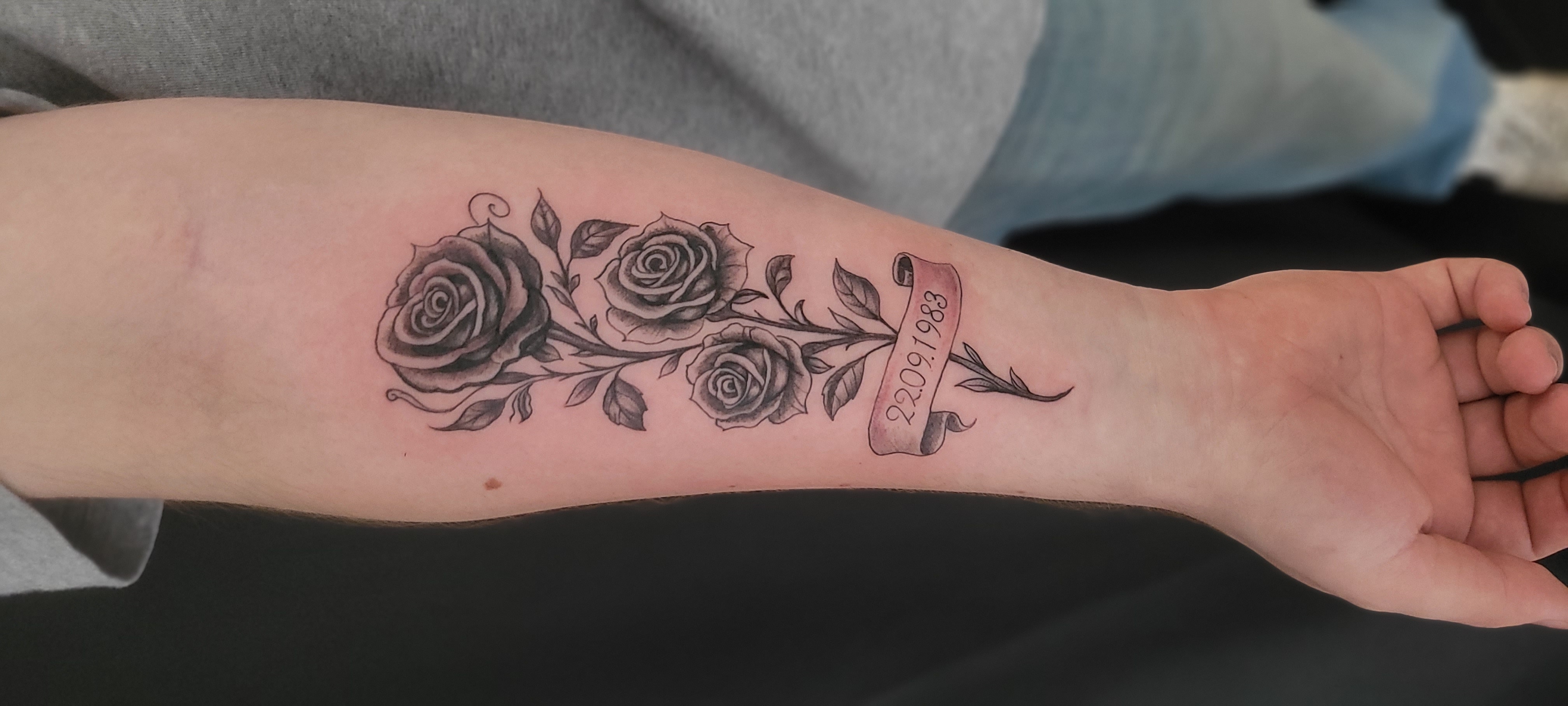 Schwarz Graues Tattoo einer Rose mit Schriftzug