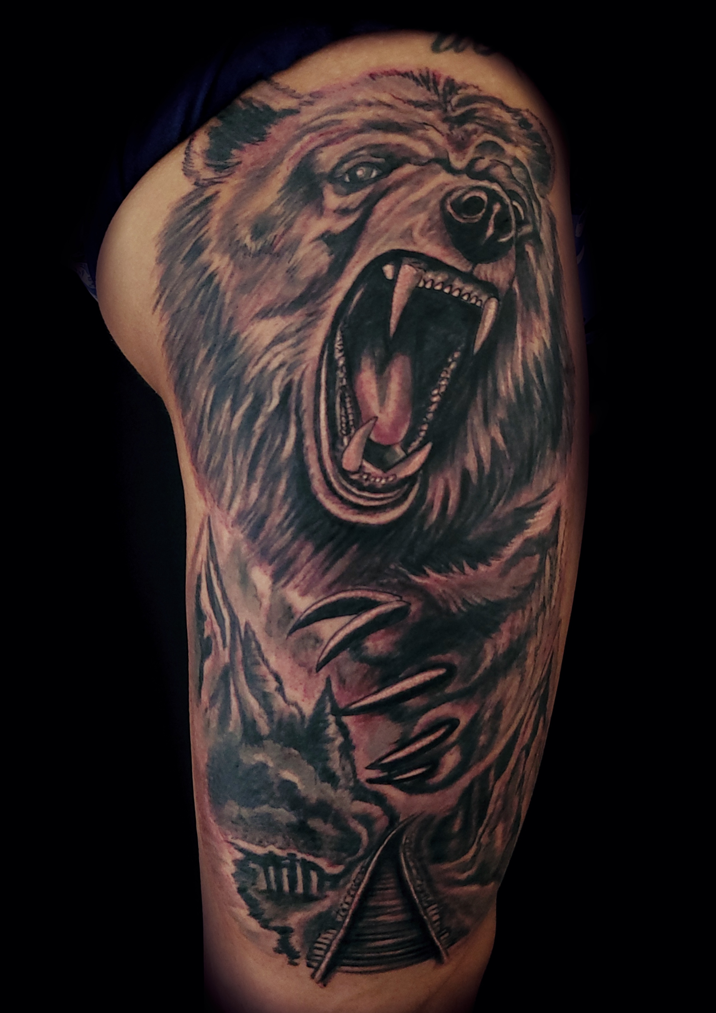 schwarz graues Tattoo von einem brüllenden Bär mit Bahnstrecke