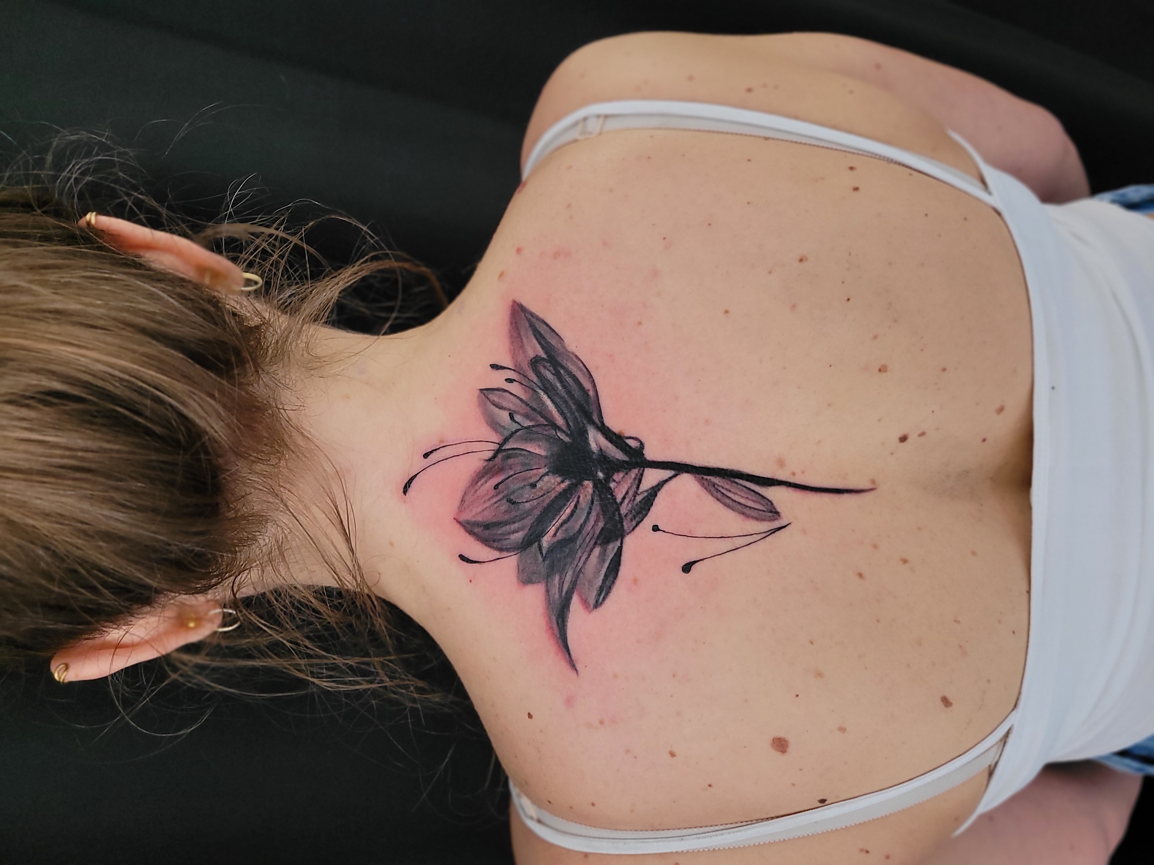 Tattoo einer großen Blume auf dem Rücken